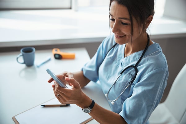 cheerful-female-doctor-using-cellphone-in-clinic-2024-10-18-17-41-37-utc