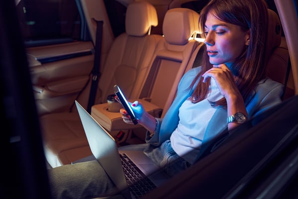 woman-using-mobile-phone-and-laptop-in-car-2022-01-18-23-45-03-utc