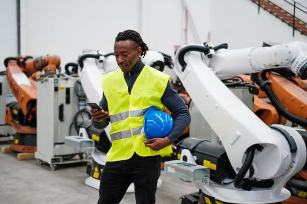young-worker-with-braids-using-the-smartphone-in-h-2023-11-27-05-07-29-utc